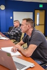 An U.S. Air Force member sits in a classroom and participates in leadership training.