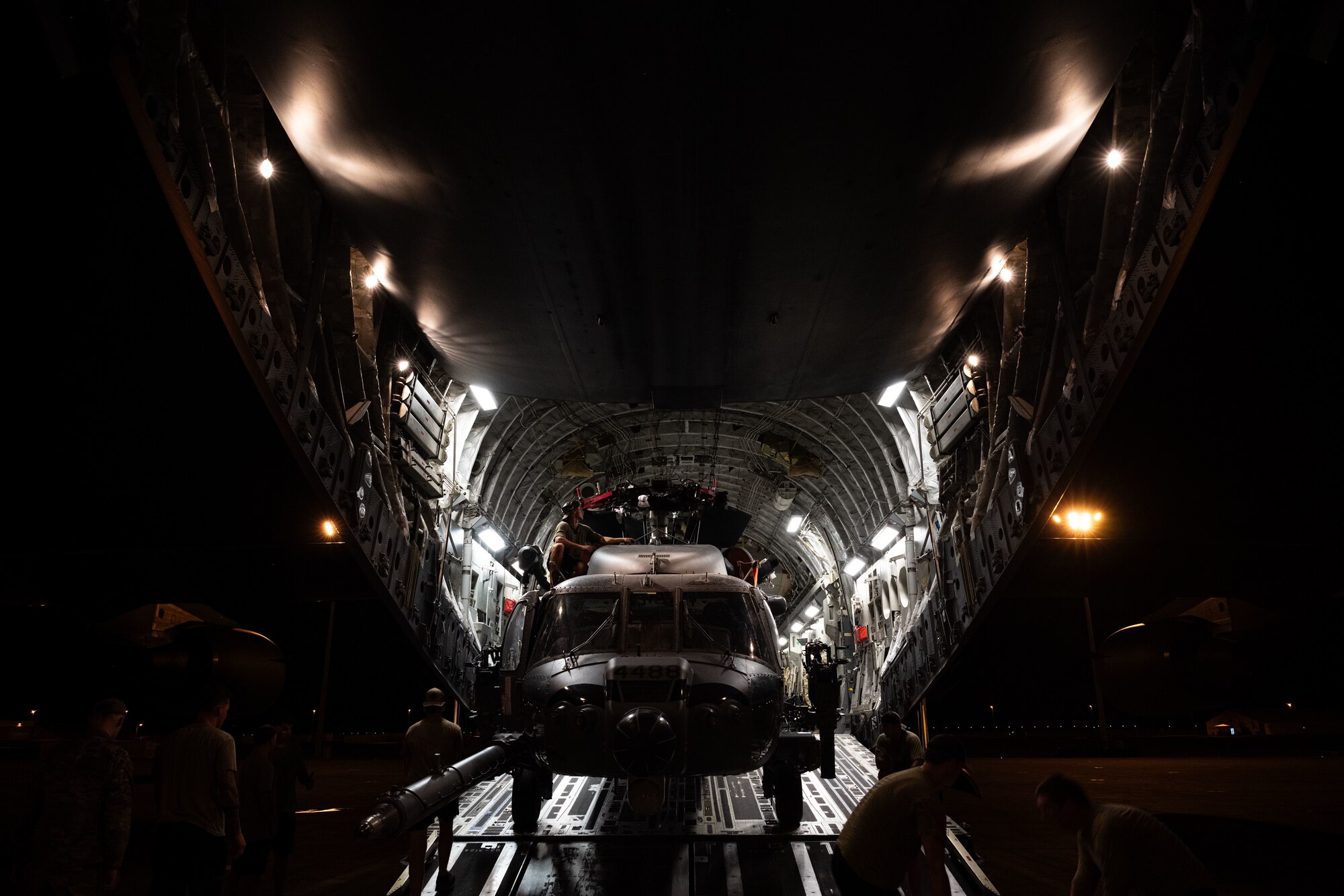 U.S. Airmen load a helicopter onto a cargo aircraft.