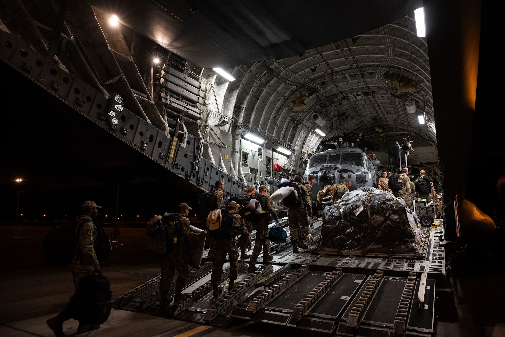U.S. Airmen load a helicopter onto a cargo aircraft.