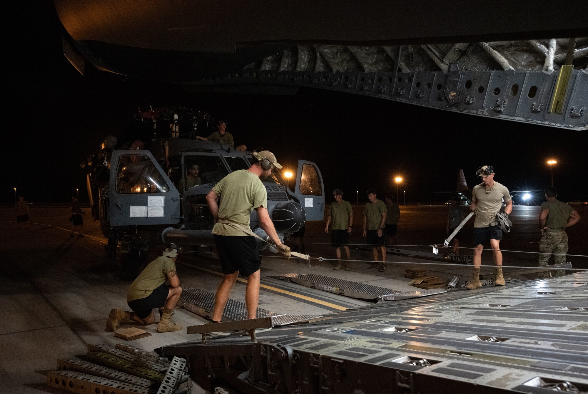 U.S. Airmen load a helicopter onto a cargo aircraft.