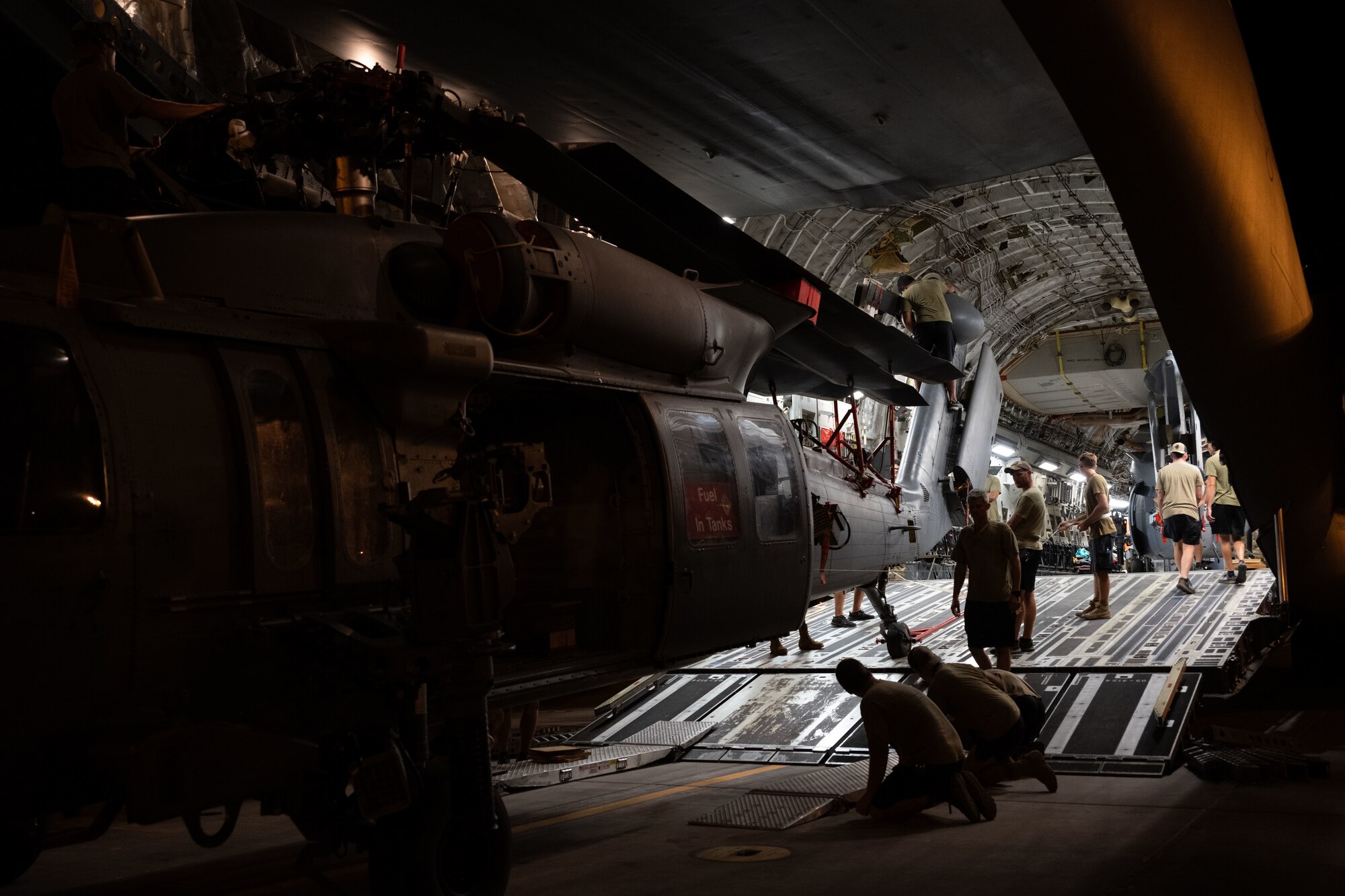 U.S. Airmen load a helicopter onto a cargo aircraft.