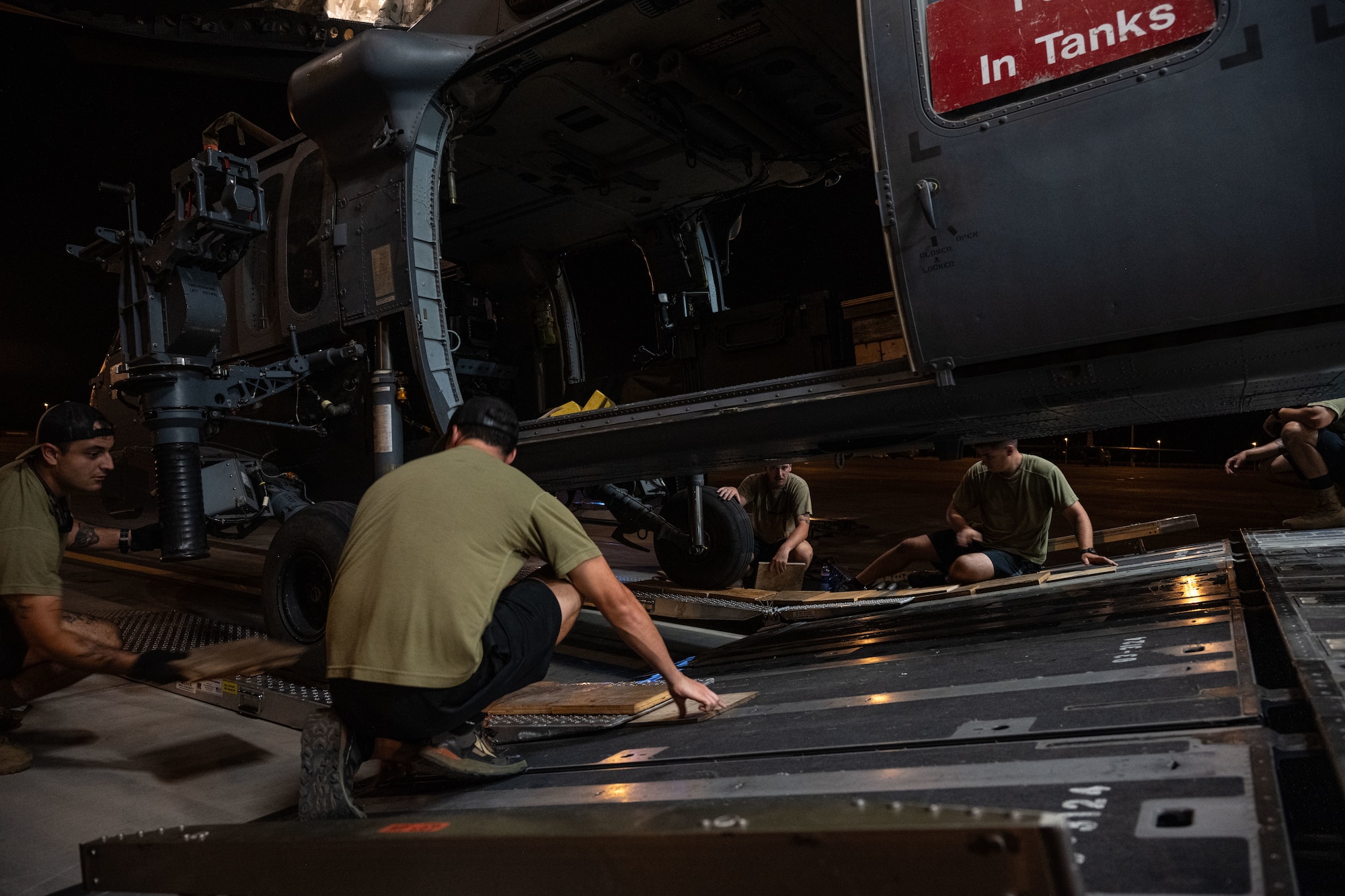 U.S. Airmen load a helicopter onto a cargo aircraft.