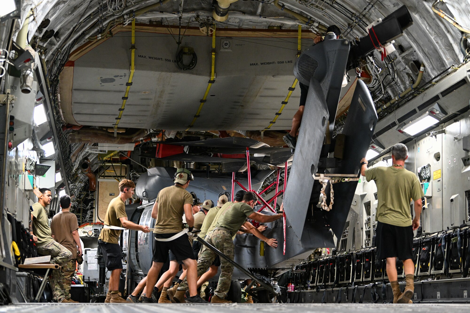 U.S. Airmen load a helicopter onto a cargo aircraft.