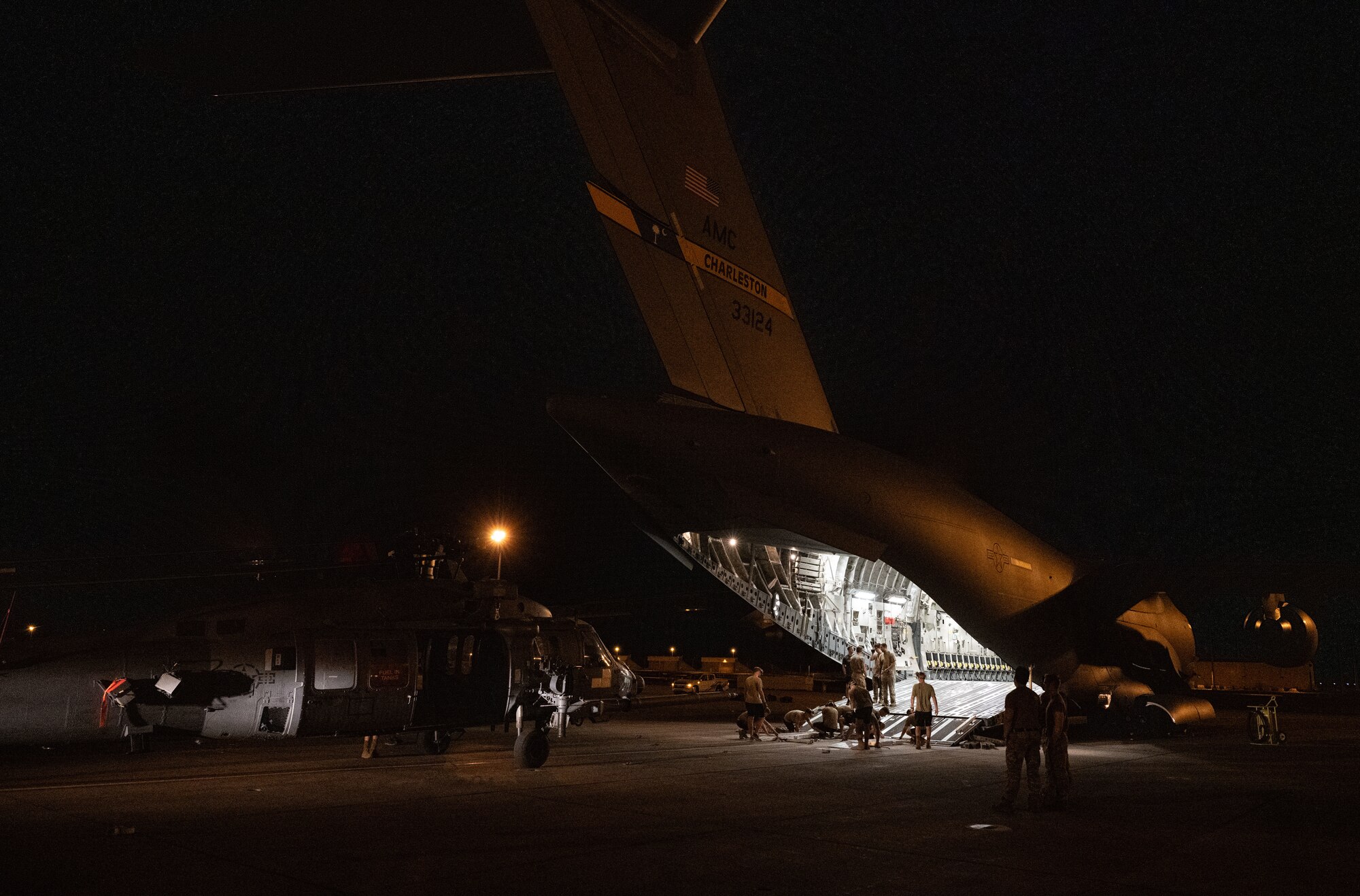 U.S. Airmen load a helicopter onto a cargo aircraft.