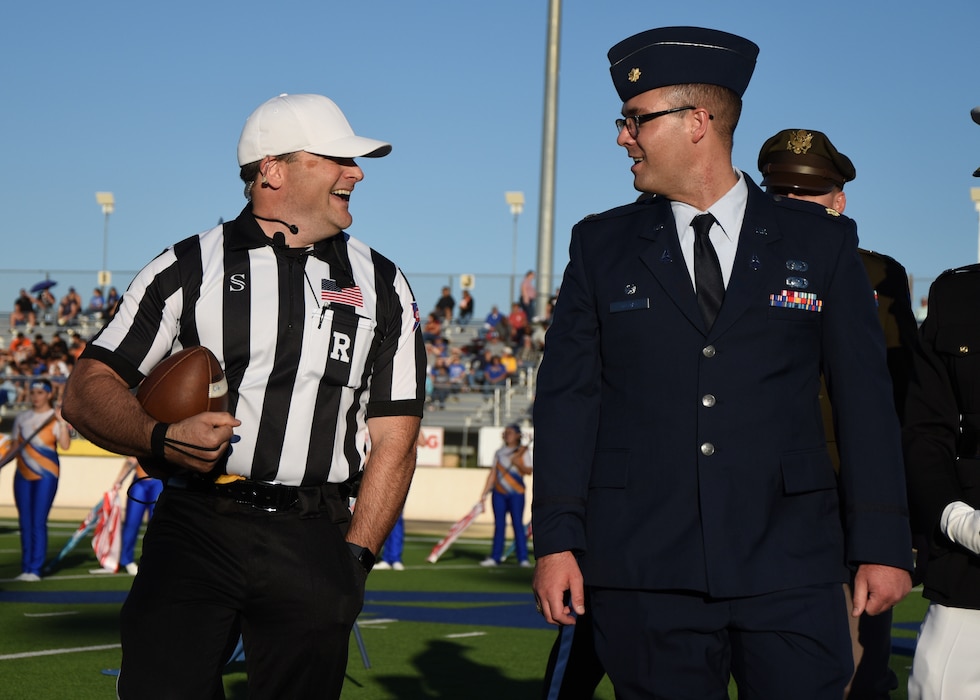 U.S. Space Force Maj. Benjamin Tillman, 533rd Training Squadron Det. 1 commander, talks with a referee at Angelo State University’s football game during Military Appreciation Day, San Angelo, Texas, Nov. 4, 2023. Joint force commanders from Goodfellow presented the game ball before the coin toss. (U.S. Air Force photo by Staff Sgt. Nathan Call)
