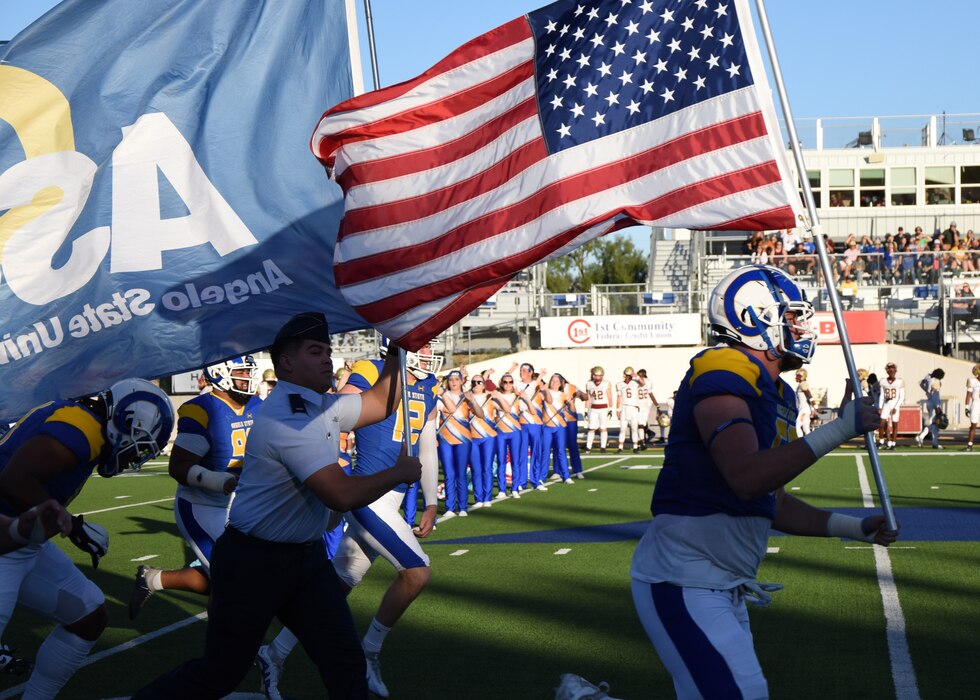 U.S. Air Force 1st Lt. Andrew Burrola, 17th Communications Squadron, runs with Angelo State University Rams during Military Appreciation Day, San Angelo, Texas, Nov. 4, 2023. ASU showed its appreciation for the armed forces throughout the day with multiple displays and events. (U.S. Air Force photo by Staff Sgt. Nathan Call)