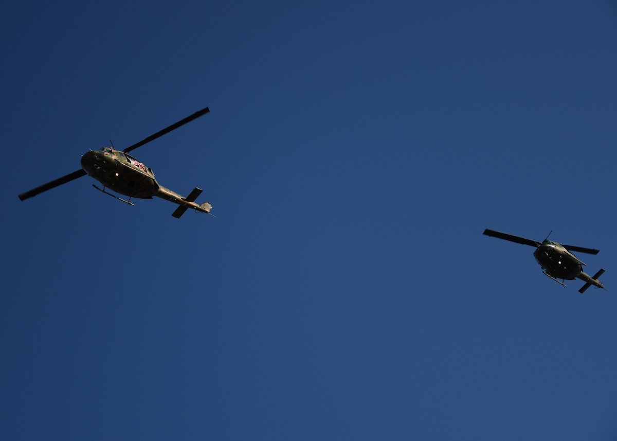 Two UH-1N Huey helicopters fly over the LeGrande Stadium during The Star-Spangled Banner for Military Appreciation Day at Angelo State University, San Angelo, Texas, Nov. 4, 2023. The Hueys were part of a static display at Ram Jam and brought veterans, civilians and active duty together. (U.S. Air Force photo by Staff Sgt. Nathan Call)