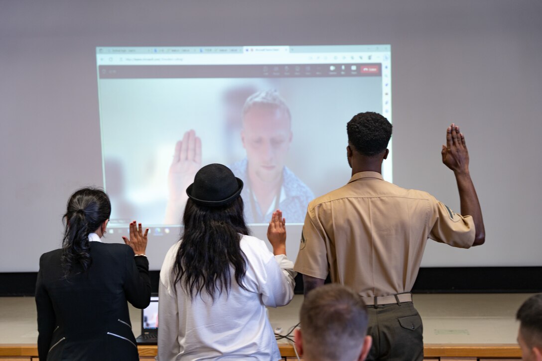 Anh Huynh, a Vietnam native, left, Wai Chan, a Hong-Kong native, center, and U.S. Marine Corps Lance Cpl. Michael Stephen, a Guyana native, recite the Oath of Allegiance during a naturalization ceremony at Marine Corps Air Station Iwakuni, Japan Oct. 31, 2023. MCAS Iwakuni regularly conducts naturalization ceremonies for new citizens. (U.S. Marine Corps photo by Lance Cpl. Brian Long)