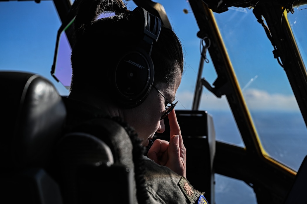A pilot looks out the window of an aircraft.