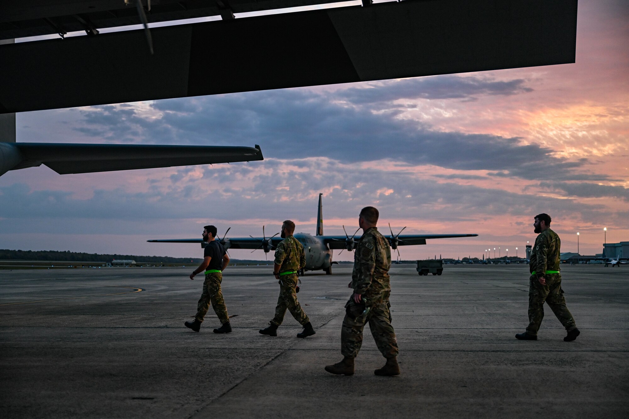 Airmen walk on the flightline.