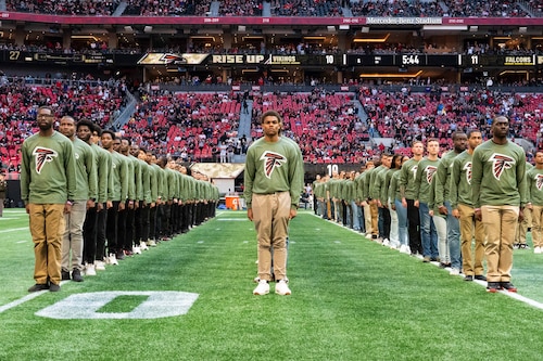 People stand on a football field.
