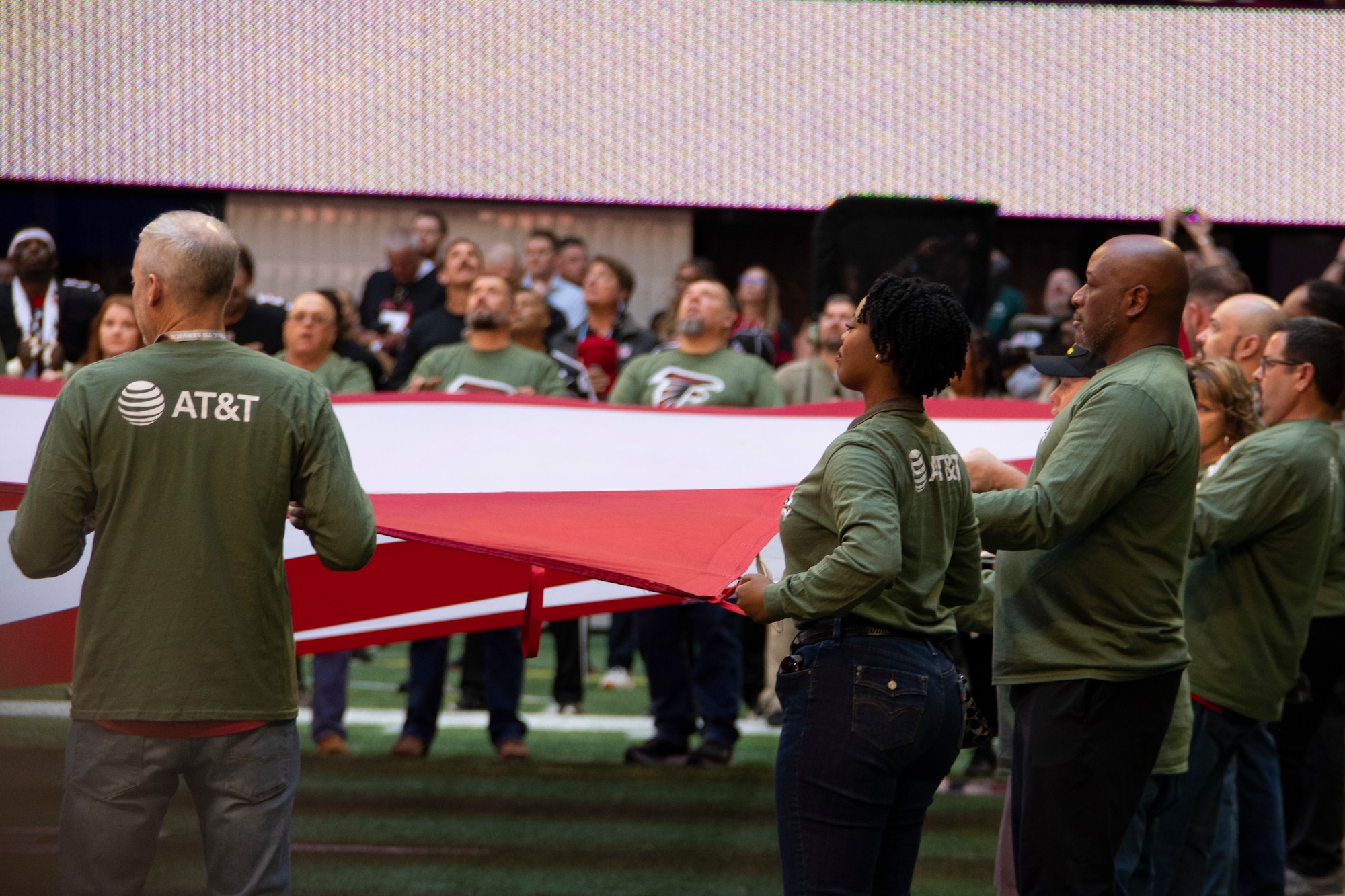 Men and women hold the U.S. flag.