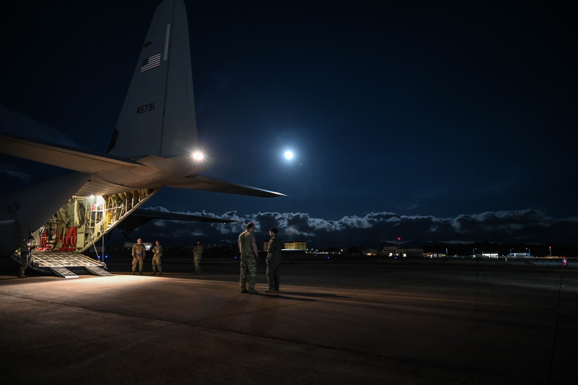 Airmen stand on the flightline.