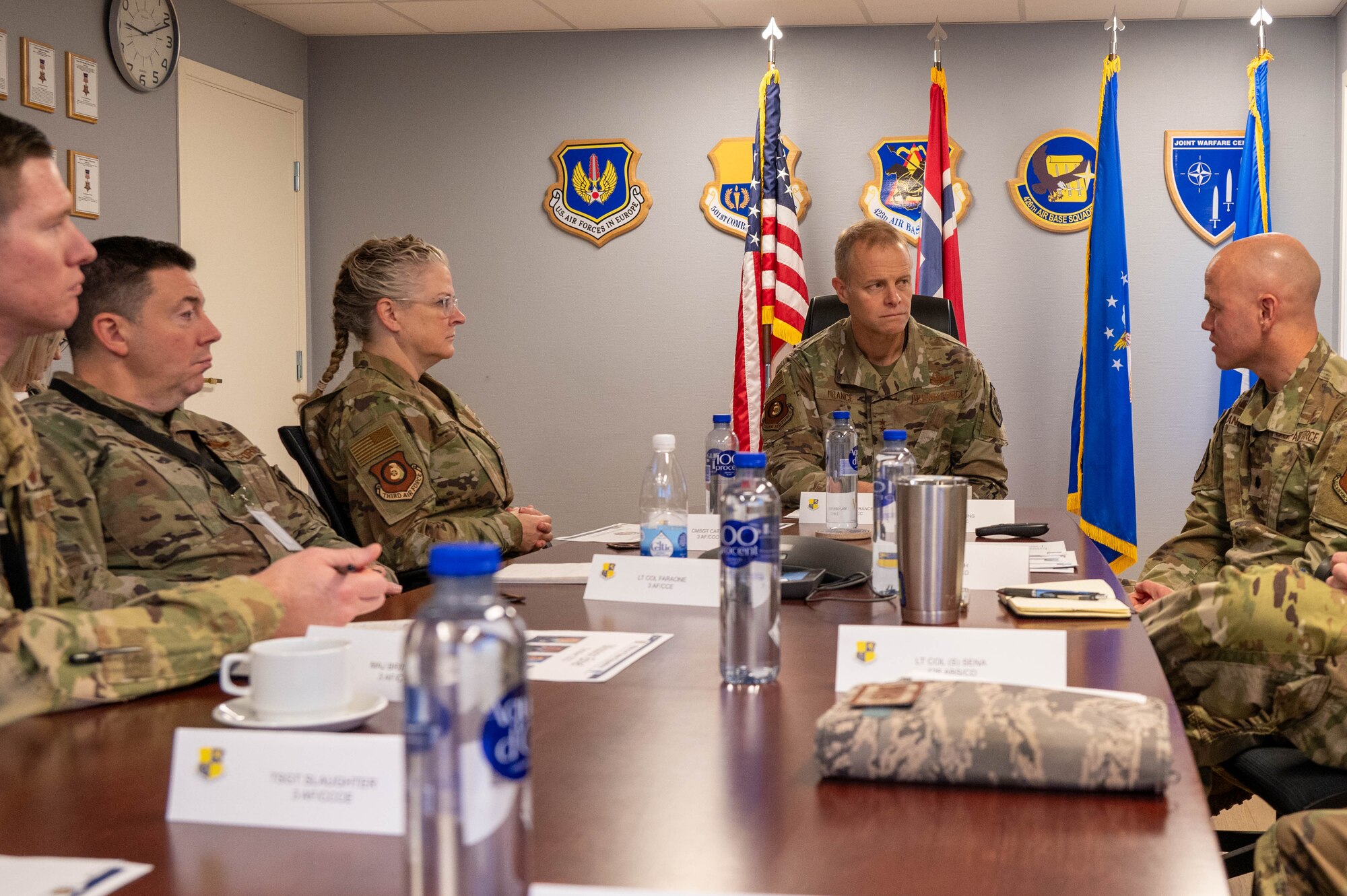 Members of the Third Air Force leadership team listen to a brief.