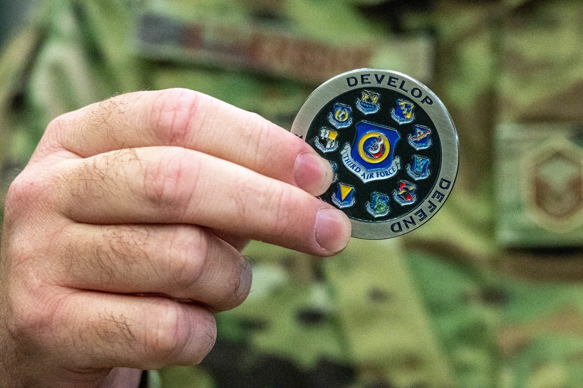 An Airman displays a Third Air Force coin.
