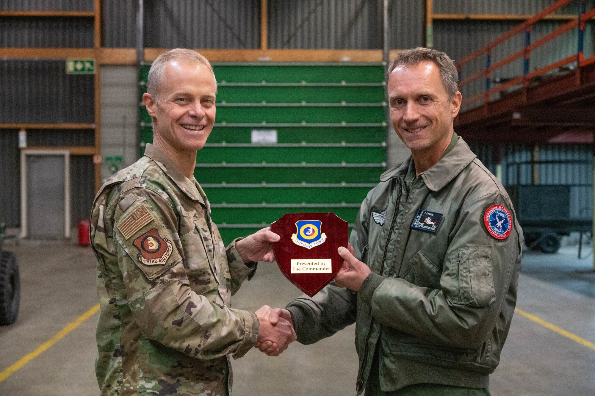 Men pose for a photo while holding a plaque.