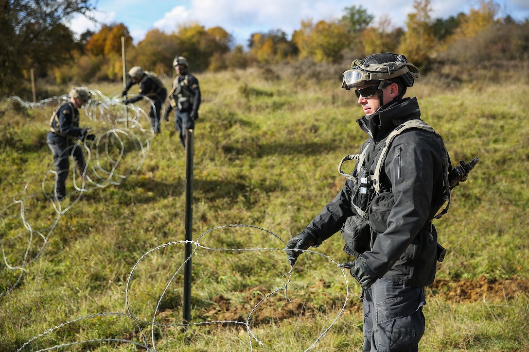 A soldier places concertina wire during a training exercise.