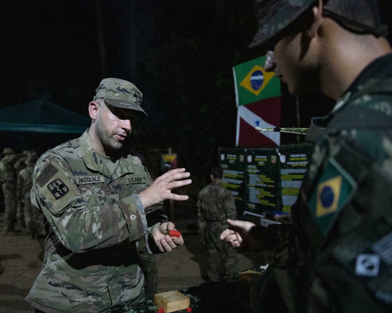 New York National Guard Sgt. 1st Class Brian Pasquale, combat medic assigned to the 466th Medical Company Area Support, discusses creating a modified shotgun shell with a Brazilian Army jungle trainer at the night portion of the jungle familiarization and academics portion of Southern Vanguard 24 in Belem, Brazil, Nov. 4, 2023. Southern Vanguard, an annual bilateral exercise that rotates between partner nations in the U.S. Southern Command area of responsibility, enhances interoperability between the United States and partner nation forces.