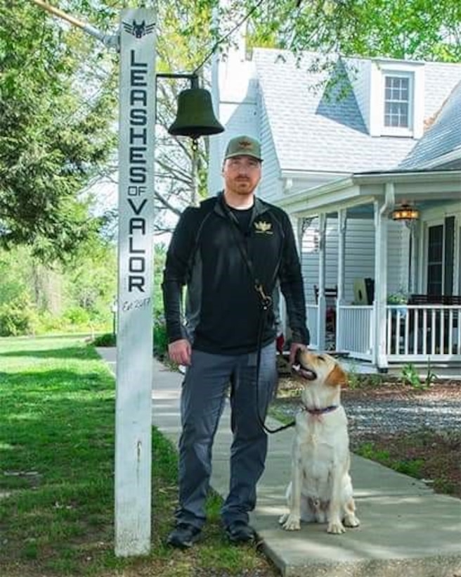 Man stands outside next to his dog