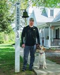 Man stands outside next to his dog