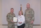 U.S. Air Force Maj. Gen. John Klein, U.S. Air Force Expeditionary Center commander and Col. Michael Freeman, 628th Air Base Wing and Joint Base Charleston commander, presents Cheryl Clark, Palmetto Military Support Group president, with the Commander’s Public Service Award medal during the Honorary Commander Induction Ceremony at Joint Base Charleston, Nov. 2, 2023.