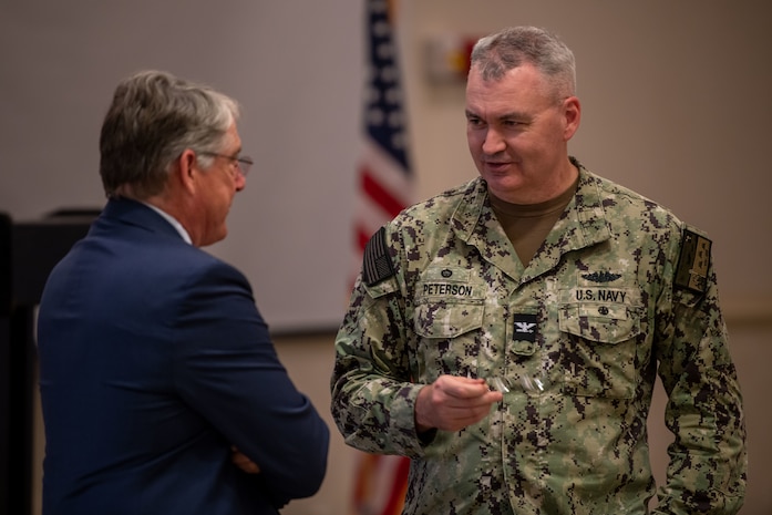 John Kopanski, Joint Base Charleston honorary commander and U.S. Navy Capt. Andrew Peterson, 628th Air Base Wing deputy commander and Naval Support Activity Charleston commander engage in conversation during an honorary commander induction ceremony on Joint Base Charleston, South Carolina, Nov. 2, 2023.
