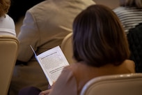 An attendee reads over a program during an honorary commander induction ceremony on Joint Base Charleston, South Carolina, Nov. 2, 2023.