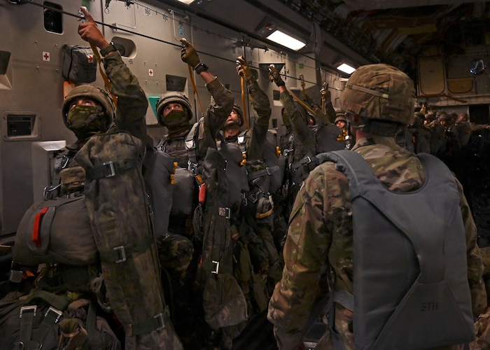 Spanish paratroopers with the Grupo De Artilleria attach their static lines on a C-17 Globemaster III assigned to Joint Base Lewis-McChord, Washington, during DEFENDER 23 over Spain, May 10, 2023. DEFENDER 23 is a U.S. Army Europe and Africa-led exercise, supported by U.S. Air Forces in Europe – Air Forces Africa, focused on the strategic deployment of continental United States-based forces and interoperability with Allies and partners. Taking place from April 22 to June 23, DEFENDER 23 demonstrates the U.S. Air Force’s ability to aggregate U.S.-based combat power quickly in Europe; increase lethality of the NATO Alliance through the U.S. Air Force’s Agile Combat Employment; build unit readiness in a complex joint, multi-national environment; and leverage host nation capabilities to increase USAFE-AFAFRICA’s operational reach. DEFENDER 23 includes more than 7,800 U.S. and 15,000 multi-national service members from various Allied and partner nations. (U.S Air Force photo by Senior Airman Callie Norton)