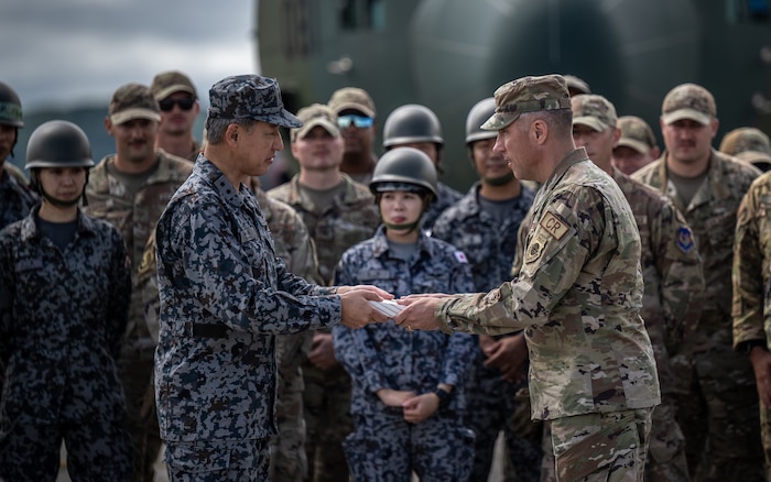Japan Air Self-Defense Force Maj. Gen. Hideaki Kajiya, deputy commander of Air Support Command, and U.S. Air Force Maj. Gen. John Klein, U.S. Air Force Expeditionary Center commander, exchange gifts on the flightline as part of Mobility Guardian 23 at Yakumo Air Base, Japan, July 13, 2023. A multilateral endeavor, MG23 featured seven participating countries: Australia, Canada, France, Japan, New Zealand, United Kingdom, and the United States—operating approximately 70 mobility aircraft across multiple locations spanning a 3,000-mile exercise area from July 5-21. (U.S. Air Force photo by Tech. Sgt. Alexander Cook)
