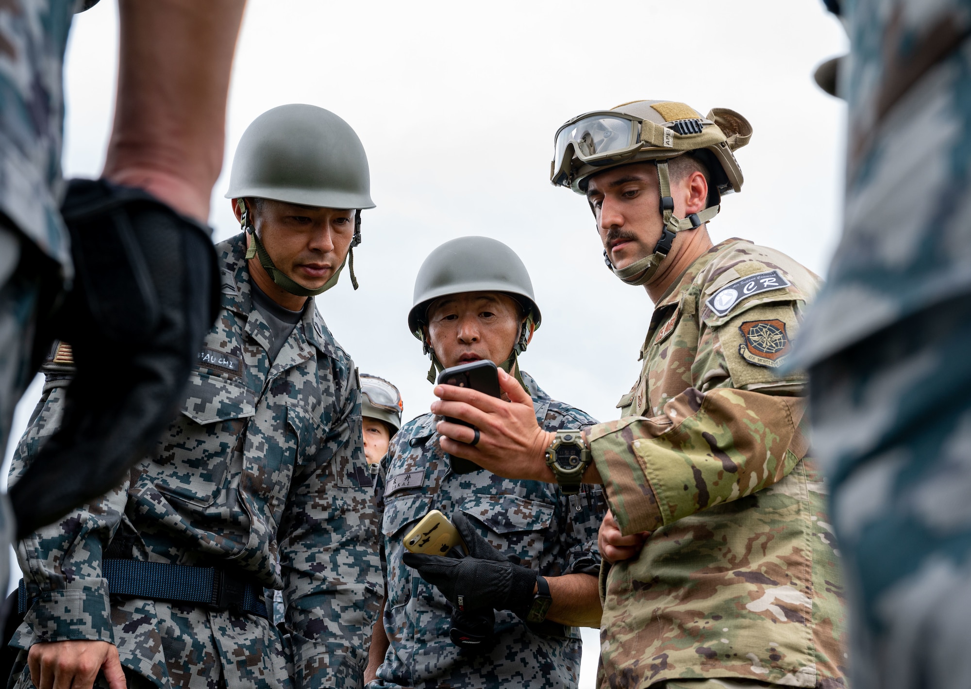 Tech. Sgt. Connor Starr, right, 821 Contingency Response Squadron fuels UTC lead, uses his phone to communicate instructions during a specialized fuel operations in support of Mobility Guardian 2023 at  Yakumo sub-base, Japan, July 12, 2023. A multilateral endeavor, MG23 features seven participating countries - Australia, Canada, France, Japan, New Zealand, United Kingdom, and the United States - Operating approximately 70 mobility aircraft across multiple locations spanning a 3,000 miles exercise are from July 5 through July 21.