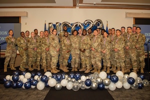U.S. Air Force Chief Master Sgt. Adrienne Warren, the 99th Air Base Wing command chief, and newly inducted noncommissioned officers (NCO) pose for a group photo during the NCO induction ceremony at Nellis Air Force Base, Nevada, Nov. 2, 2023.