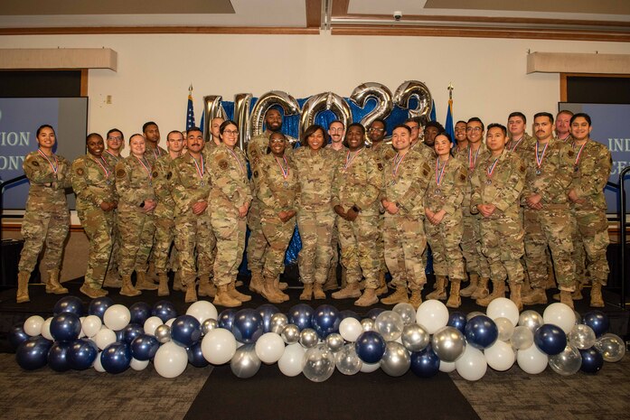 U.S. Air Force Chief Master Sgt. Adrienne Warren, the 99th Air Base Wing command chief, and newly inducted noncommissioned officers (NCO) pose for a group photo during the NCO induction ceremony at Nellis Air Force Base, Nevada, Nov. 2, 2023.