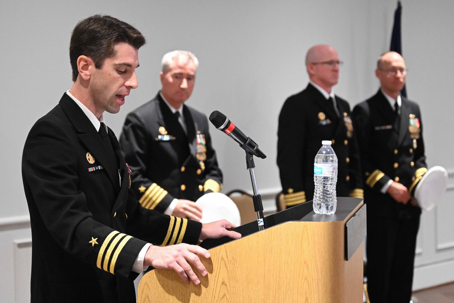 Cmdr. Matthew Brouillard, commanding officer of the Los Angeles-class fast-attack submarine USS Columbus (SSN 762), reads his orders during a change of command ceremony at the Mariner’s Museum and Park in Newport News, Virginia.
