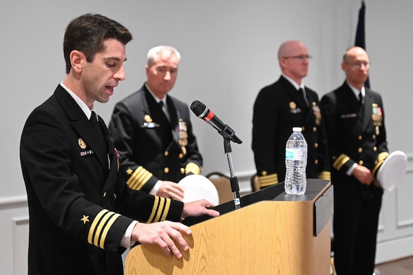 Cmdr. Matthew Brouillard, commanding officer of the Los Angeles-class fast-attack submarine USS Columbus (SSN 762), reads his orders during a change of command ceremony at the Mariner’s Museum and Park in Newport News, Virginia.