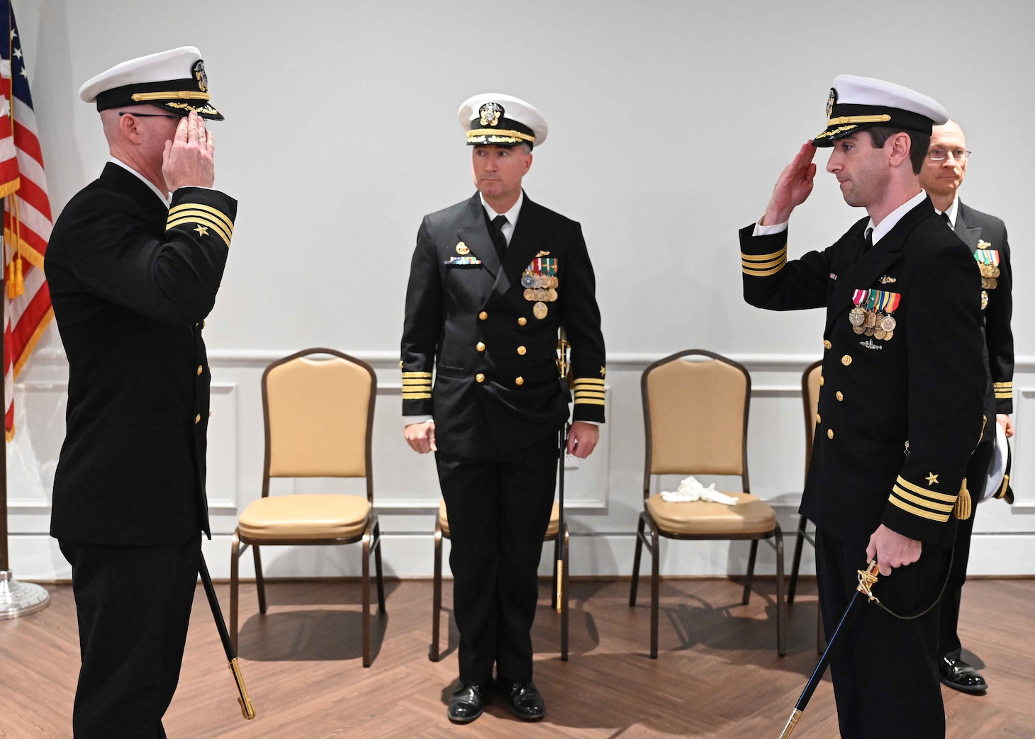 Cmdr. Russell Jones, left, relieves  Cmdr. Matthew Brouillard, right, as commanding officer of the Los Angeles-class fast-attack submarine USS Columbus (SSN 762), during a change of command ceremony at the Mariner’s Museum and Park in Newport News, Virginia.