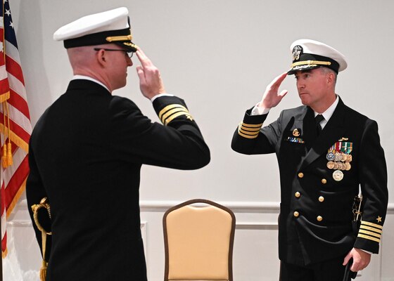 Cmdr. Russell Jones, left, commanding officer of the Los Angeles-class fast-attack submarine USS Columbus (SSN 762), renders a salute to Capt. Brian Hogan, commodore, Submarine Squadron Eight, during a change of command ceremony at the Mariner’s Museum and Park in Newport News, Virginia.