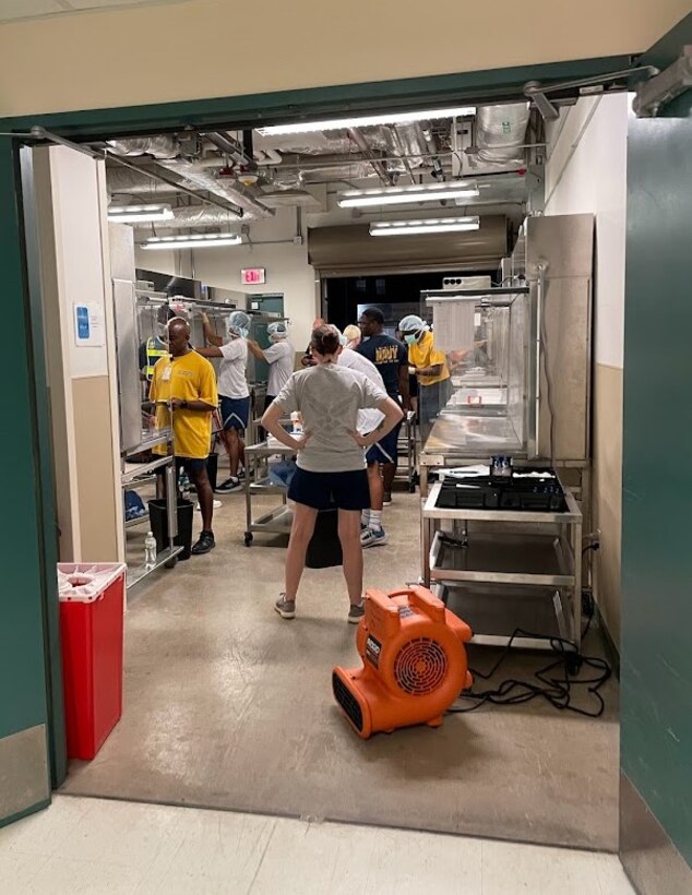 A group of Pharmacy students begin their mock practical exam on outpatient pharmacy hoods located in the loading dock of Heritage Hall.