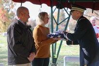 Army Capt. Mitchell Hagen presents a flag to Fran Dankovic of Lexington, Ohio, in honor of her great-uncle, U.S. Army Sgt. John F. Rowaltof Bellville, Ohio, Nov. 4, 2023. Rowalt served during the Indian Wars before contracting smallpox and dying. His gravesite had been unmarked for 148 years.