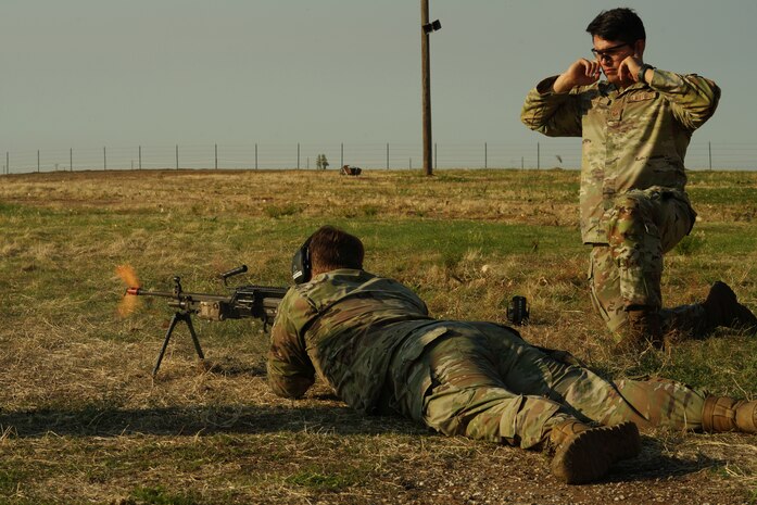 U.S. Air Force Senior Airman Taylor Dennis, 9th Aircraft Maintenance Squadron electrical and environmental technician, shoots an M249 while Staff Sgt. Michael Courey, 9th Security Forces Squadron defender, supervises during the Multi-Capable Airmen Tier-1 course Oct. 18, 2023, at Beale Air Force Base, California.