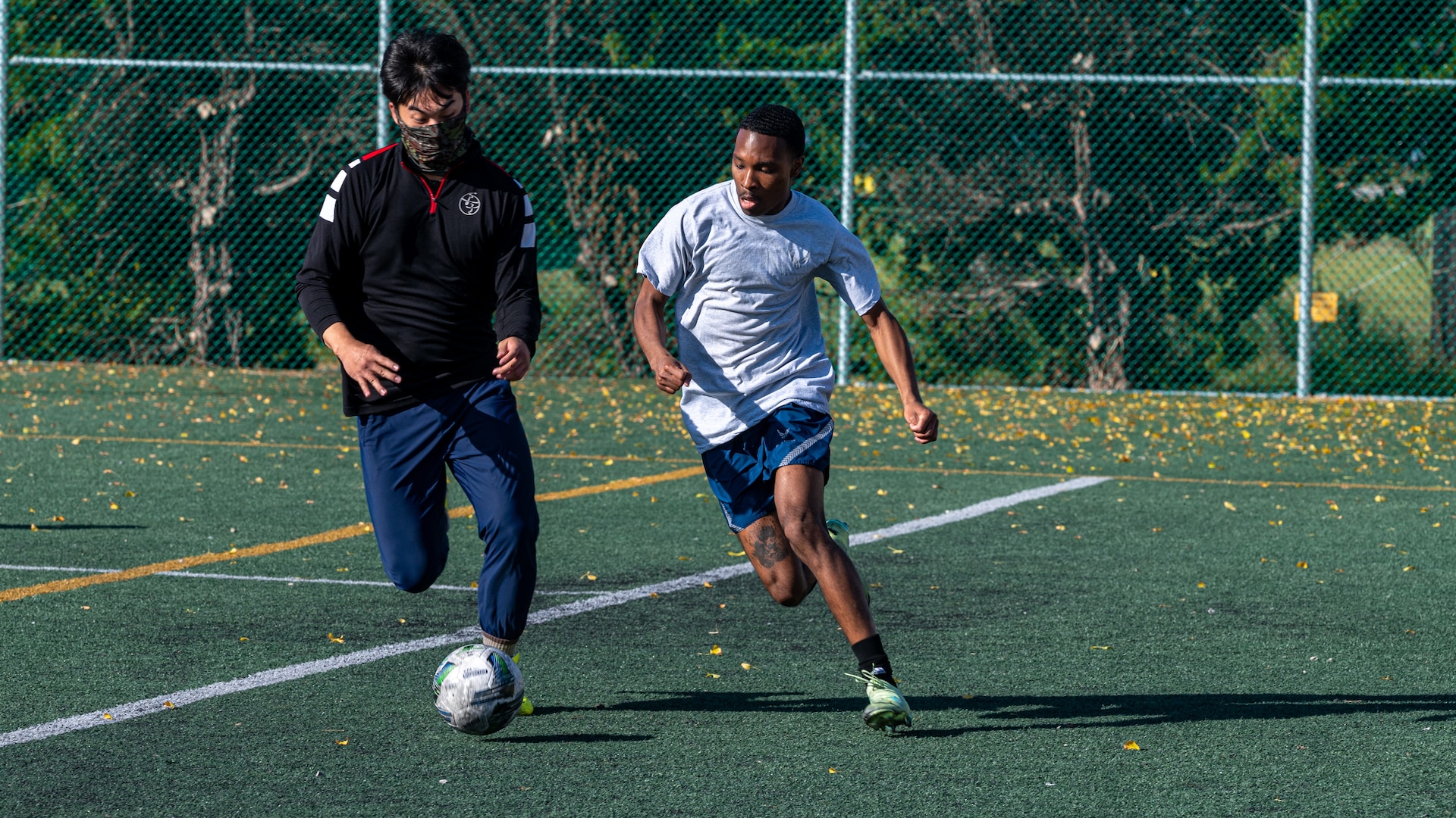 A U.S. Air Force Airman and a Republic of Korea Air Force Airman play for possession of a loose live ball during a soccer exhibition match