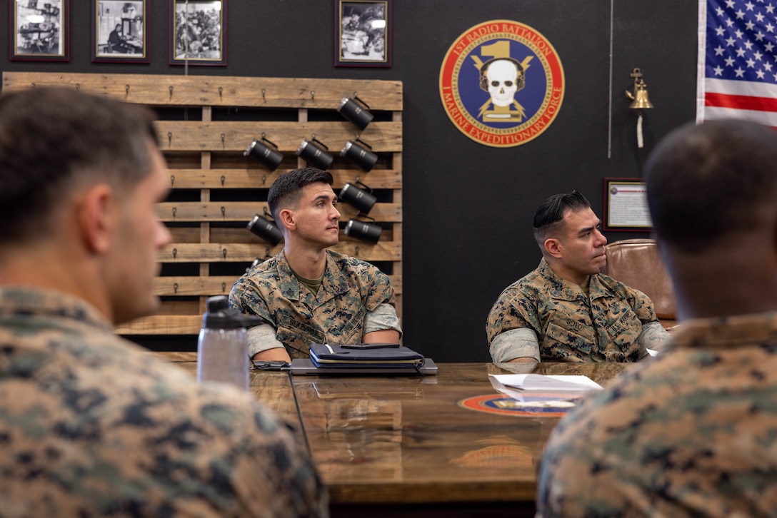 U.S. Marine Corps Sgt. Ilya Glazunov, left, a data systems technician, and Gunnery Sgt. Joseph Soto, right, a communications chief, both with I Marine Expeditionary Force Information Group reserve detachment, listen during an overview brief on the I MIG Individual Mobilization Augmentee unit at Marine Corps Base Camp Pendleton, California, Nov. 1, 2023. During their activation, the Individual Mobilization Augmentee detachment conducted annual training requirements to ensure the reservists can seamlessly transition into I MIG operations during any future activation. (U.S. Marine Corps photo by Lance Cpl. Macie Ross)