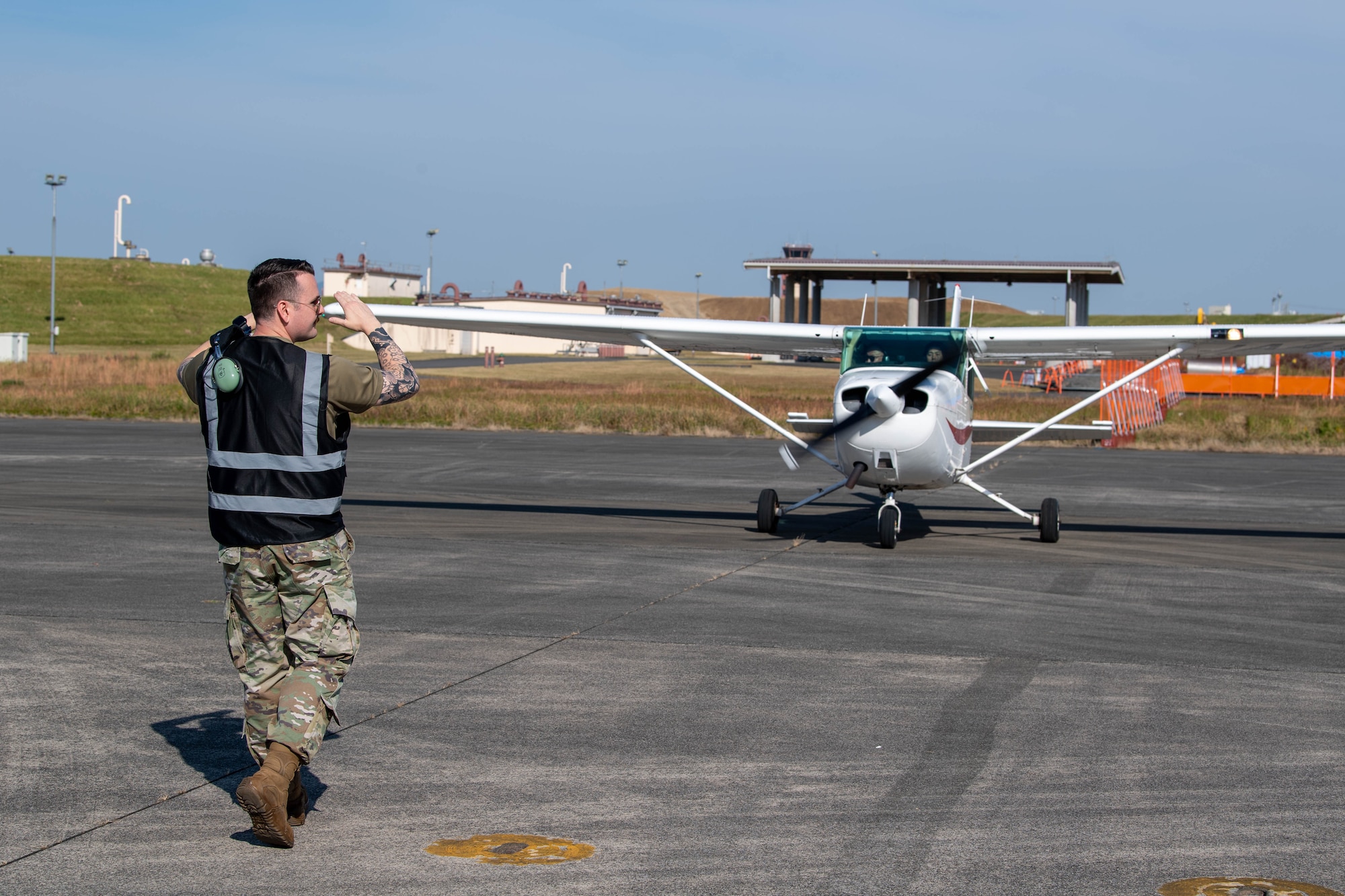 An airman marshals a civilian aircraft.