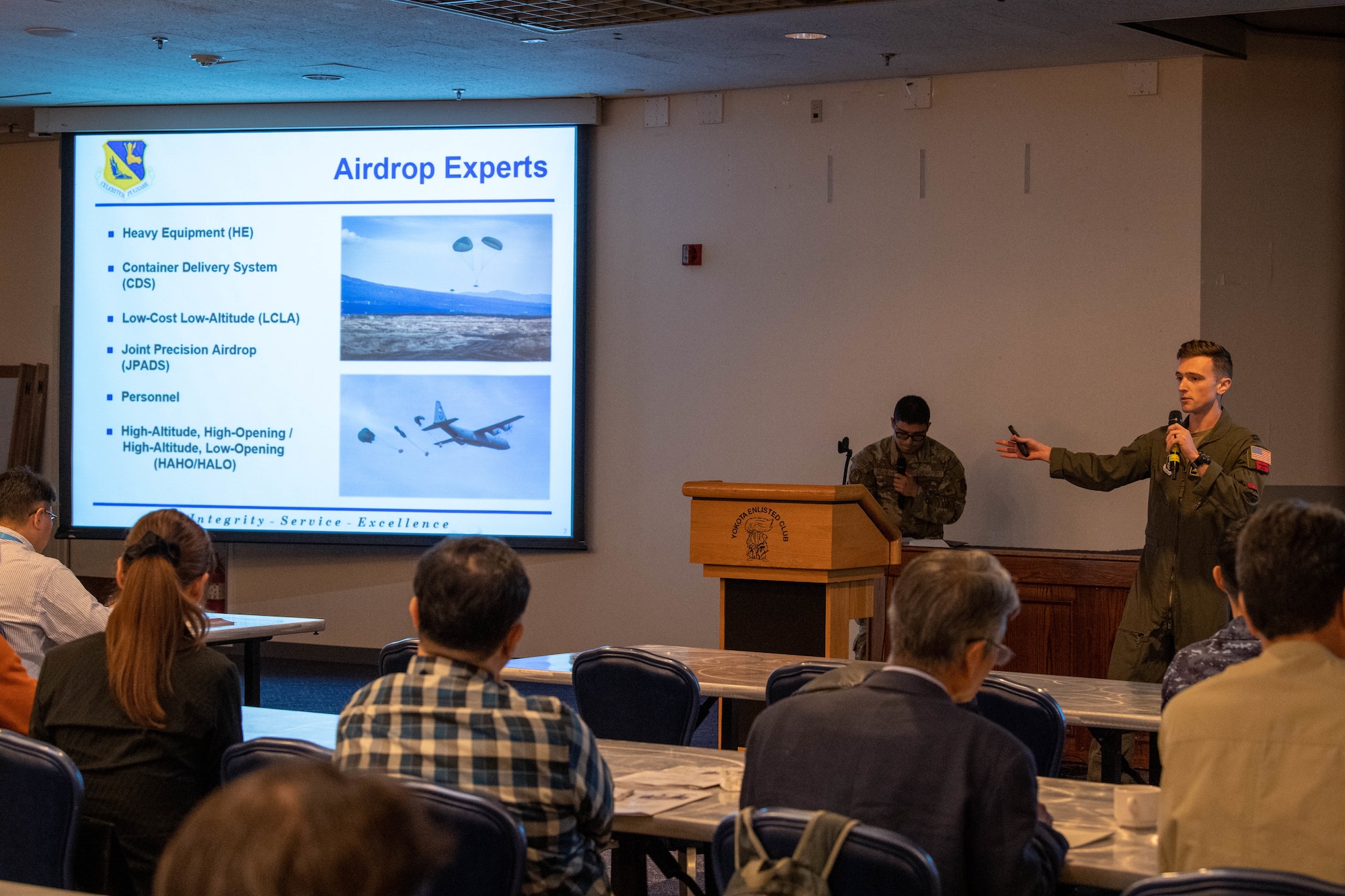 A U.S. Air Force pilot delivers a briefing at a conference.