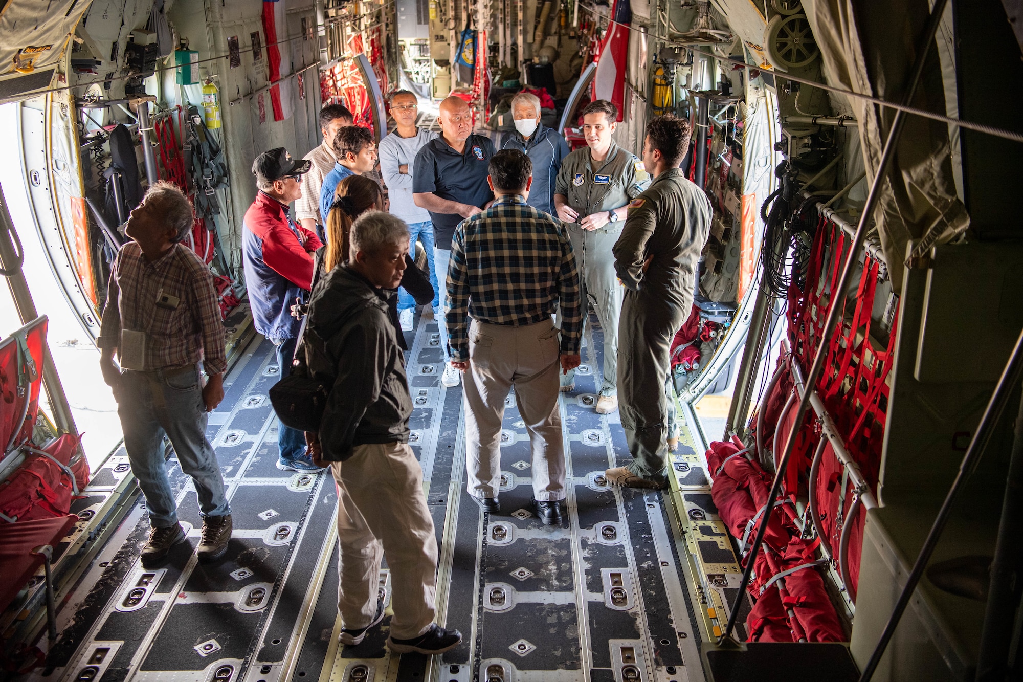 A U.S. Air Force pilot speaks to Japanese civilians inside a military aircraft.