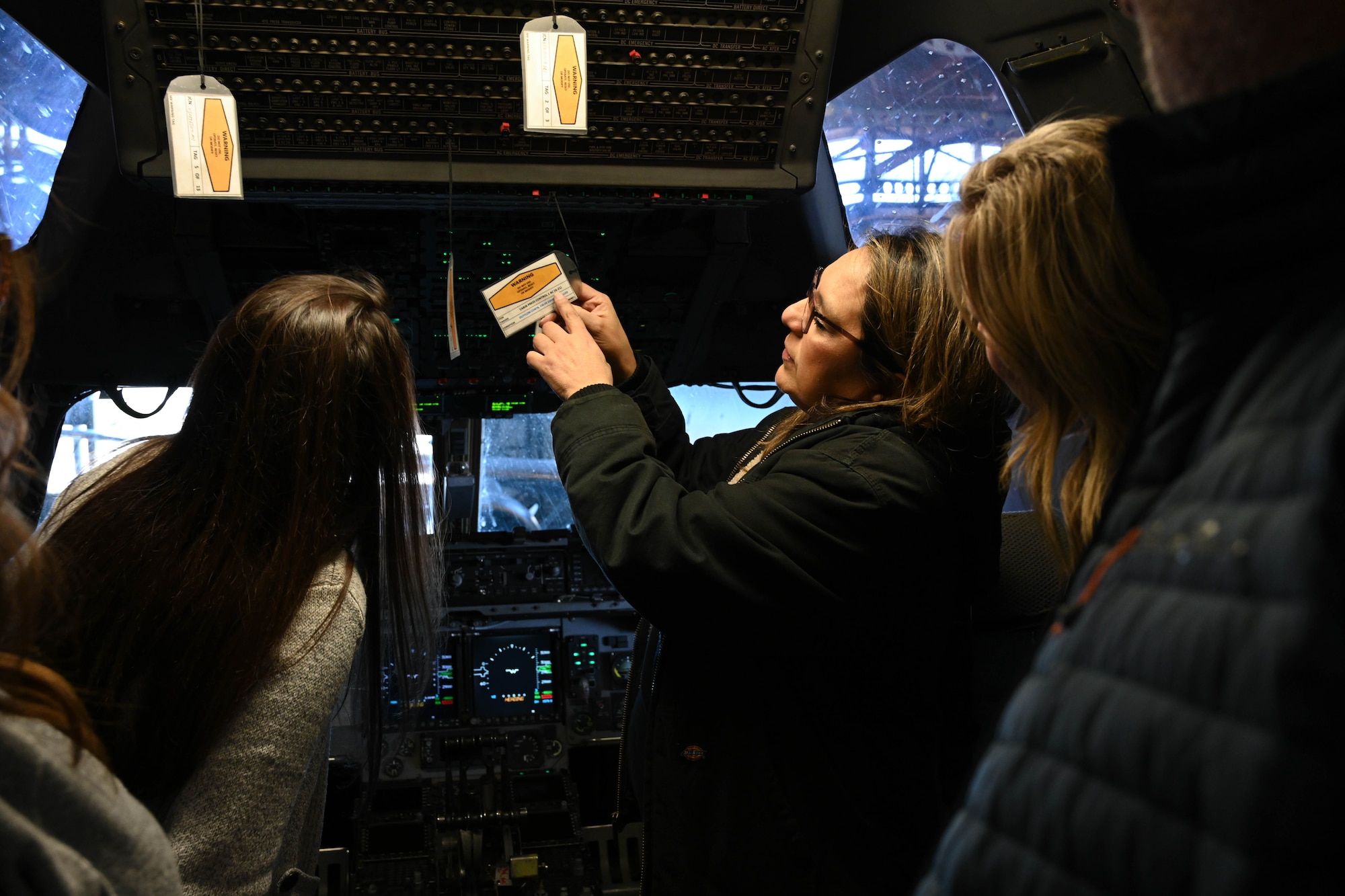 Joanna Malloy, 97th Aircraft Maintenance Squadron aircraft mechanic, shows warning tags on the panel of a C-17 Globemaster III to Altus Military Affairs Committee members during an orientation tour at Altus Air Force Base, Oklahoma, Nov. 2, 2023. Malloy explained the mechanisms of the control panel and the purpose of the warning tags. (U.S. Air Force photo by Senior Airman Miyah Gray)