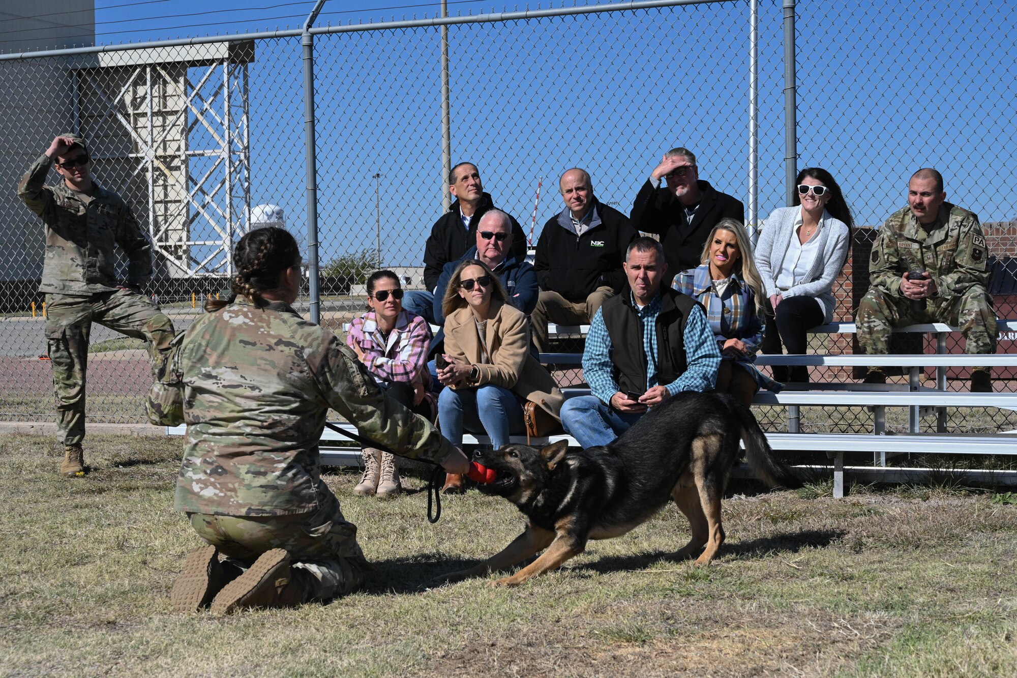 U.S. Air Force Senior Airman Kaitlynd Newland, 97th Security Forces Squadron (SFS) military working dog (MWD) handler, and Bingo, 97th SFS MWD, give a demonstration to members of the Altus Military Affairs Committee during an orientation tour at Altus Air Force Base, Oklahoma, Nov. 2, 2023. Newland and Bingo demonstrated attack training and running through an obstacle course, both of which provide the dog and the handler with training in case of real-life scenarios. (U.S. Air Force photo by Senior Airman Miyah Gray)