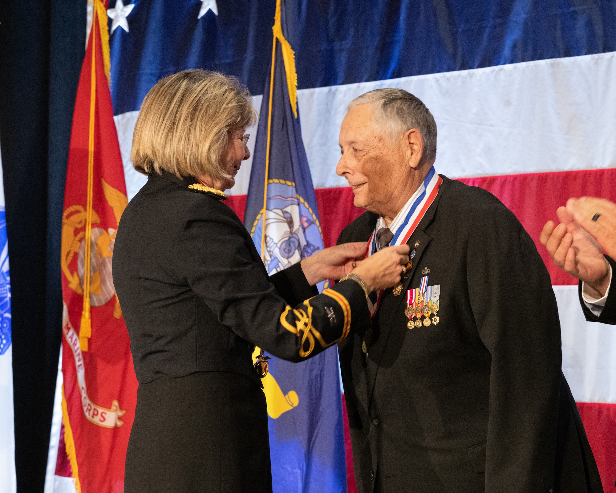 Woman putting medallion around man's head