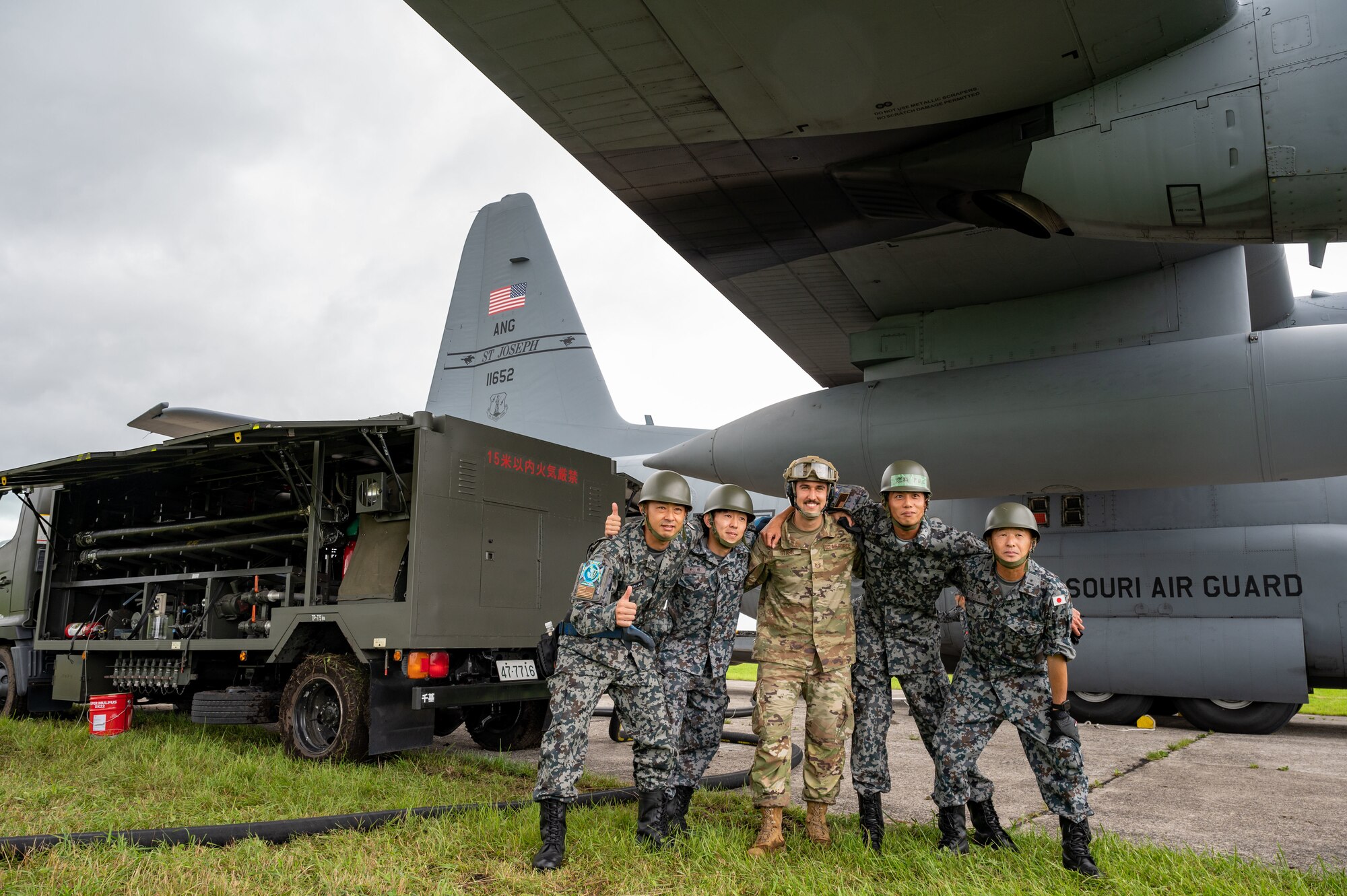 Tech. Sgt. Connor Starr, 821 Contingency Response Squadron fuels UTC lead, poses for a photo with Japanese Air Self-Defense Force members after a successful specialized fuel operations on a C-130 Hercules in support of Mobility Guardian 2023 at  Yakumo sub-base, Japan, July 13, 2023. A multilateral endeavor, MG23 features seven participating countries - Australia, Canada, France, Japan, New Zealand, United Kingdom, and the United States - Operating approximately 70 mobility aircraft across multiple locations spanning a 3,000 miles exercise are from July 5 through July 21.