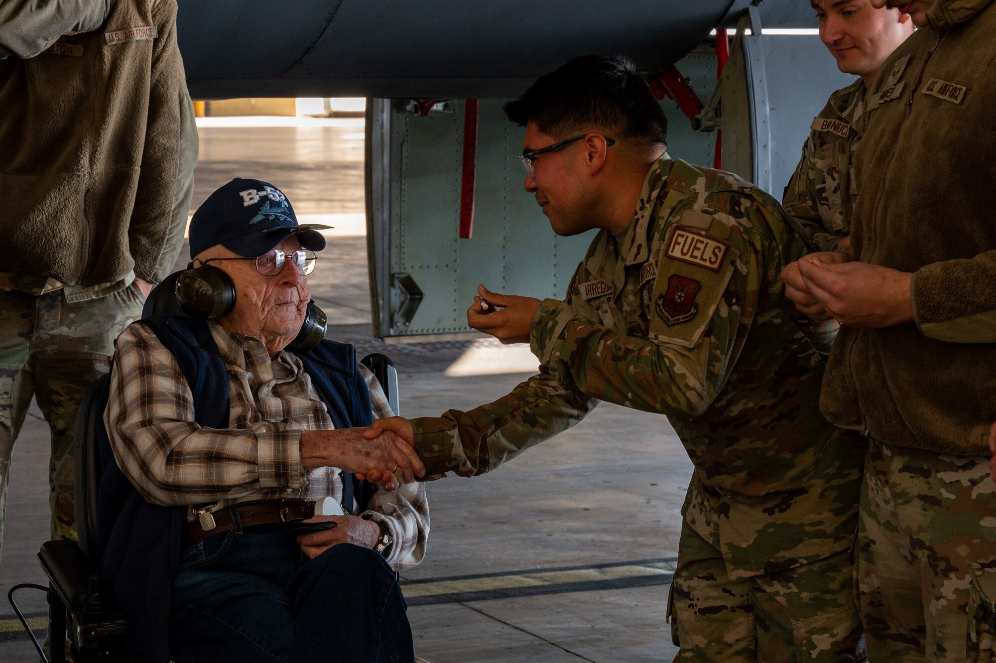 Airman Joshua Arreguin, a 2nd Maintenance Squadron fuel system specialist, shakes hands with retired Senior Master Sgt. John McNeece during McNeece's tour at Barksdale Air Force Base, La., October 18, 2023. McNeece was among the first generation of B-52 maintainers during his time in service from 1952 until 1975. (U.S. Air Force photo by Airman 1st Class Seth Watson)
