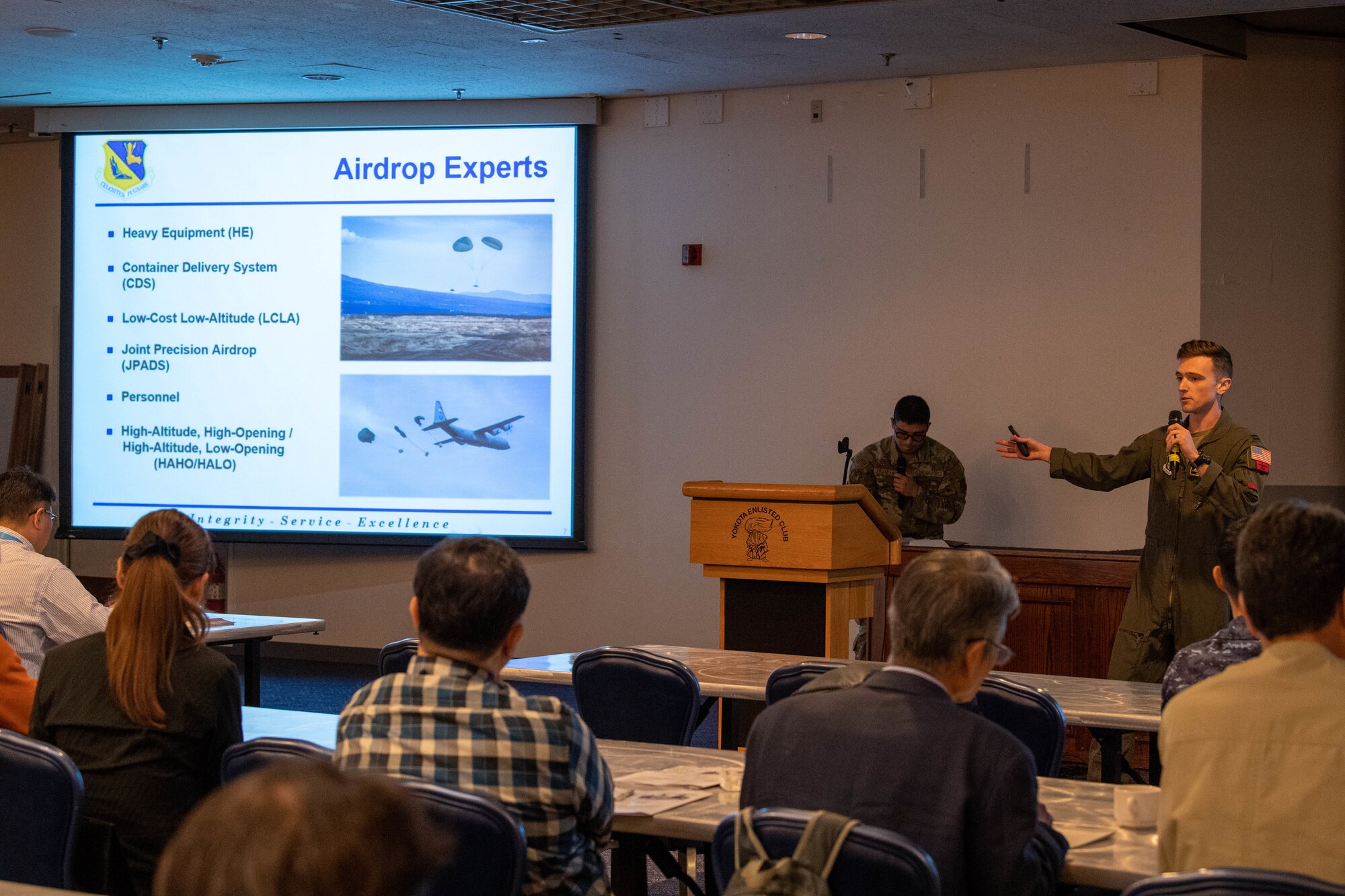 A U.S. Air Force pilot delivers a briefing at a conference.